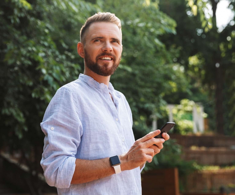 op_happy-young-bearded-man-outdoors-using-mobile-B9D43PN-min